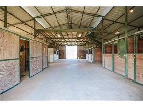 Wide aisles, tack room, and a view of the hay loft above. Hay lo